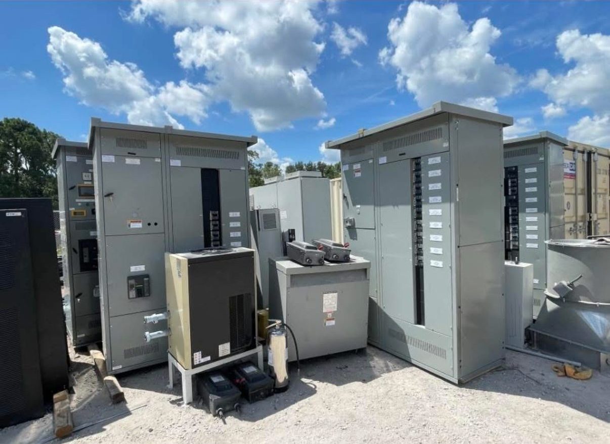 Yard full of surplus electrical panels, transformers, and switchgear we acquired